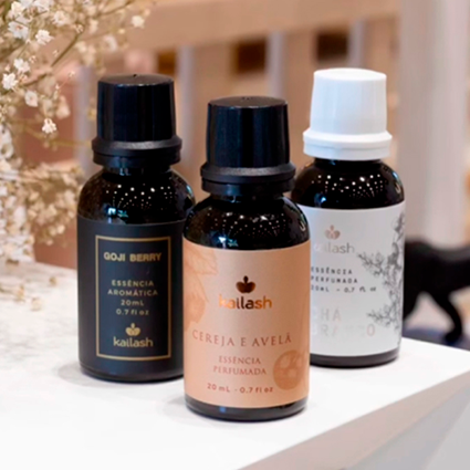 Três vidros de essência da marca Kailash de diferentes aromas, como cereja e avelã.